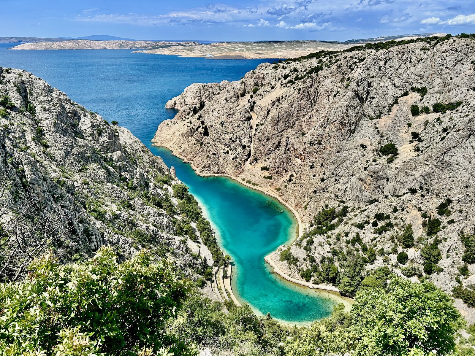 Zavratnica Cove seen from above, with turquoise water, limestone slopes and the coastal footpath